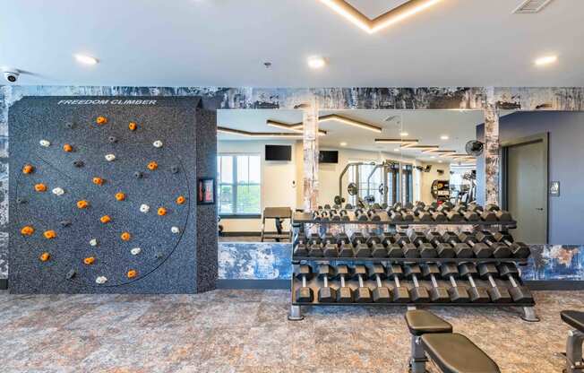 a large training room with a large row of chairs and a rock climbing wall