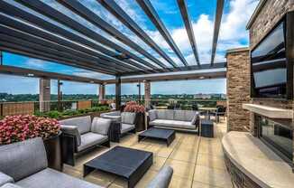 A patio with grey couches and a black coffee table.