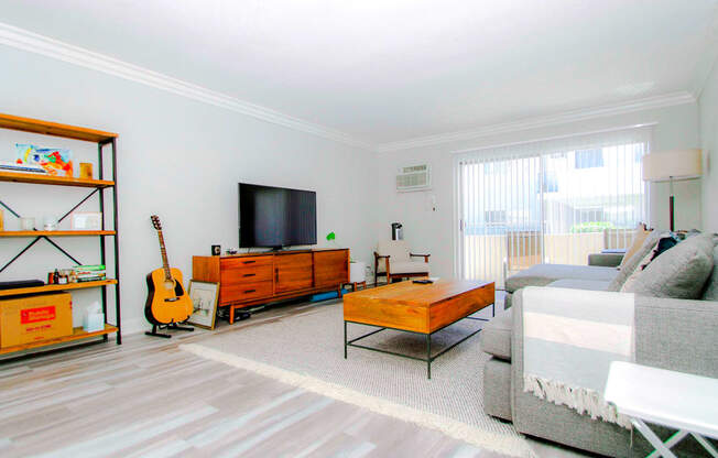 Living room with hardwood floor and large patio windows.