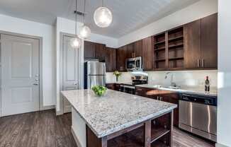 The Crosby at The Brickyard modern kitchen with granite countertops and wooden floors Apartments near DFW