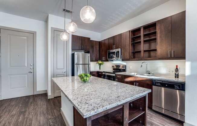 The Crosby at The Brickyard modern kitchen with granite countertops and wooden floors Apartments near DFW