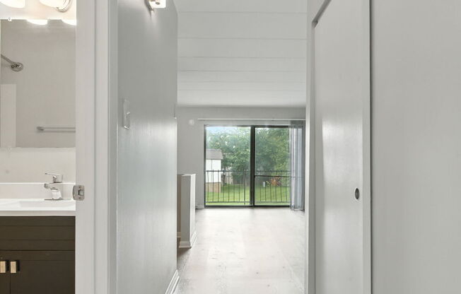 A long hallway with white walls and wood floors.