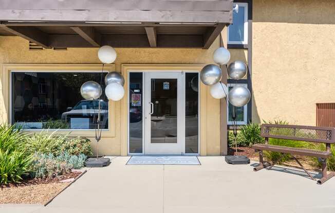 the front of a building with a door and a bench