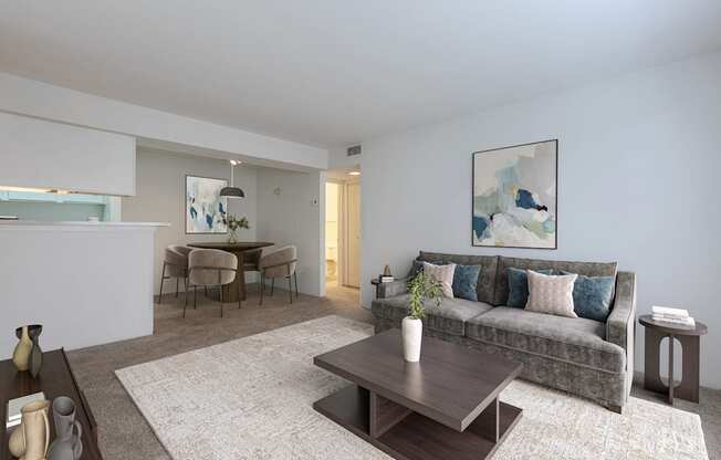 A living room with a grey couch and a coffee table in the middle.