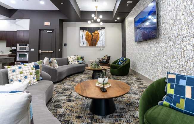 A living room with a grey couch, a green armchair, and a wooden coffee table.