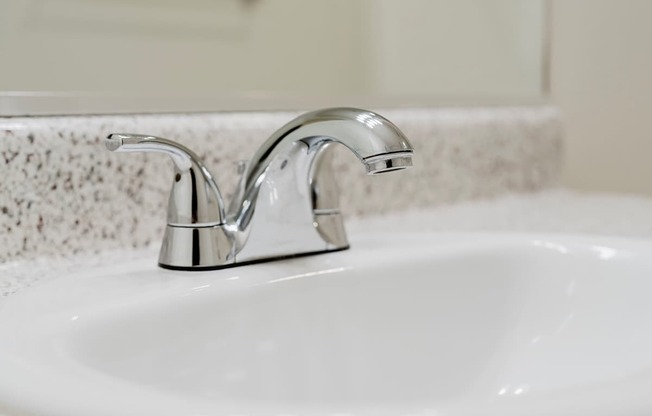 A white sink with a chrome faucet.