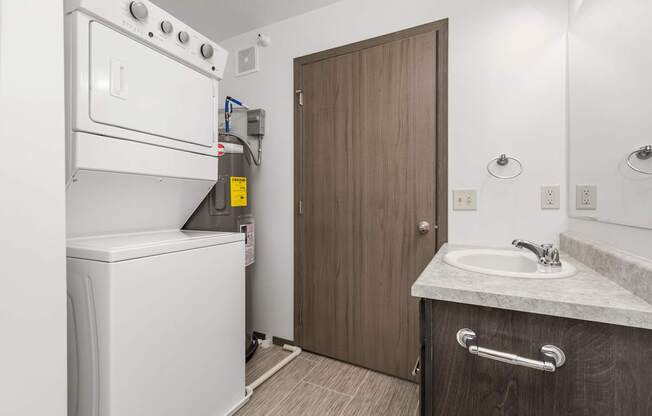 A small bathroom with a washer and dryer built into the cabinetry.