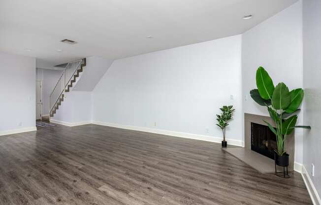 a living room with white walls and a fireplace and a green plant