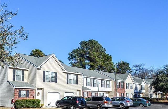 a row of houses with cars parked in front of them
