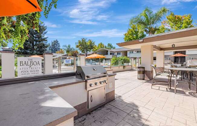 A patio with a BBQ grill and chairs is shown.