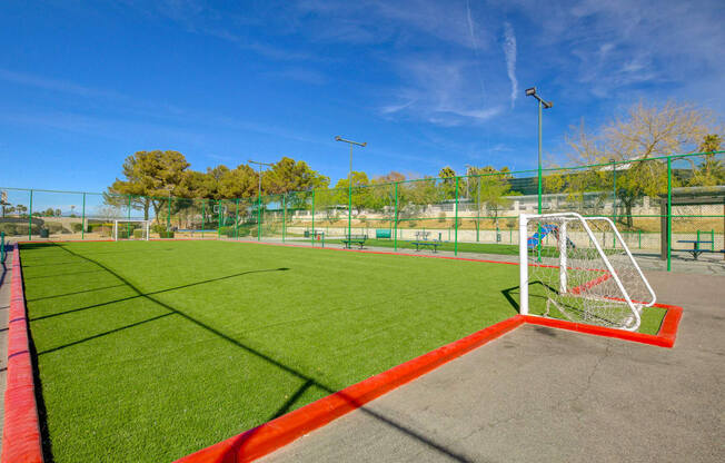 a soccer field with green grass and a red border around it