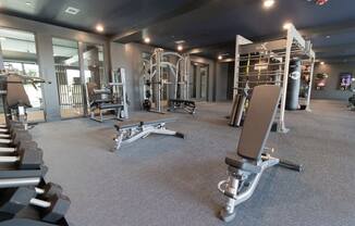 a gym with weights and other equipment in a building with glass doors