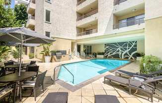 A large outdoor pool area with a table and chairs.