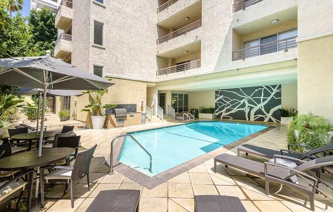 A large outdoor pool area with a table and chairs.