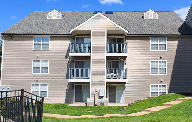A large apartment building with a black gate in front.