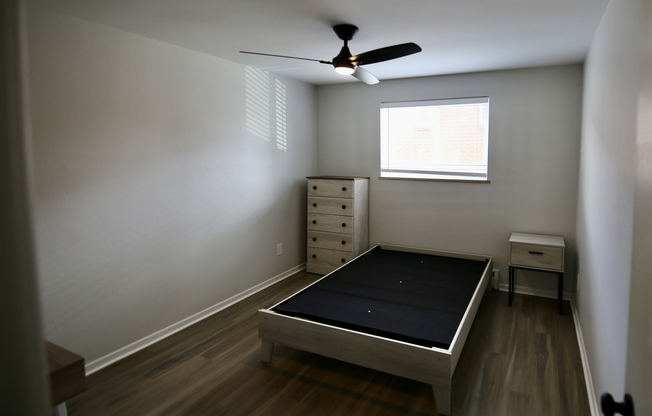 Bright and elegant bedroom with modern flooring, minimalist furniture, and ample natural light.