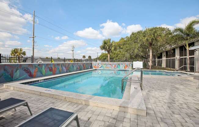A pool with a mural on the wall next to it.