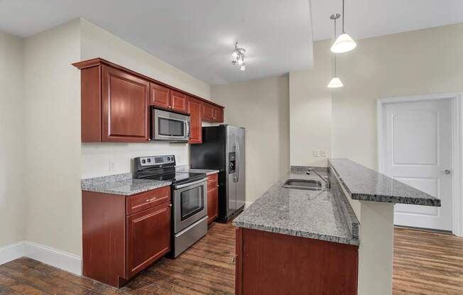 A kitchen with a granite countertop and wooden cabinets.