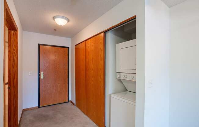 a laundry room with a washer and dryer and a door to a closet.  Eagan, MN Glen Pond Apartments