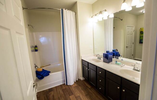 A bathroom with a white shower curtain and a white sink.