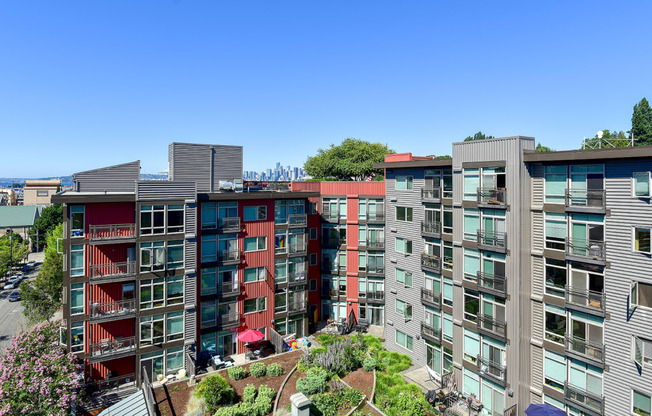 an aerial view of an apartment complex with trees and a blue sky in the background