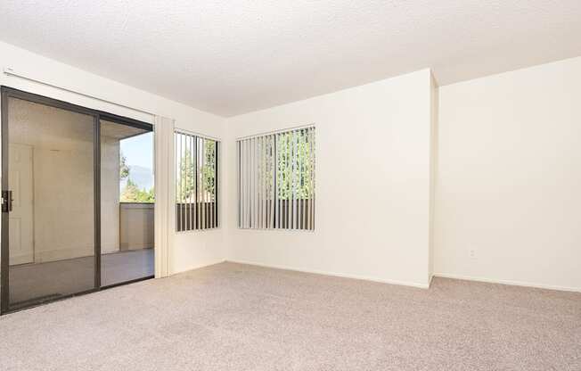 Living room with windows and balcony door at Woodbend, Alta Loma, CA