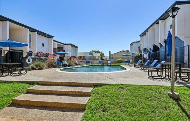 A pool surrounded by a concrete patio and steps.