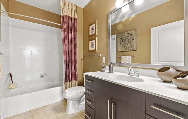 A bathroom with a white tub, toilet, and sink.