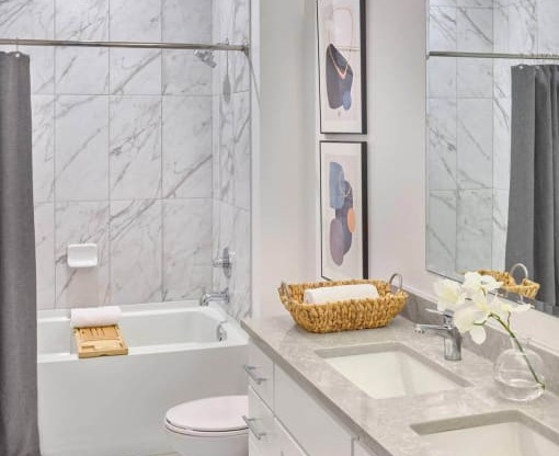 a white bathroom with a toilet and a tub and a sink at The Encore at Ingram Manor, Pikesville, MD, 21208