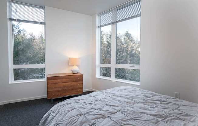 a bedroom with a bed and three windows