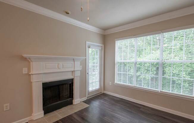 A room with a fireplace and a window with blinds.