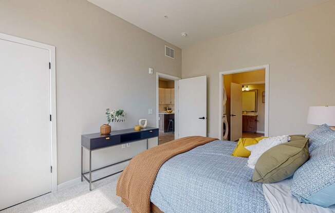 a bedroom with a blue bedspread and yellow pillows