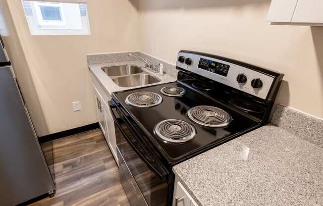 an empty kitchen with a stove and a sink