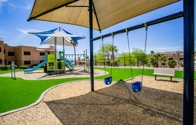 a playground with a swing set and swings and a bench