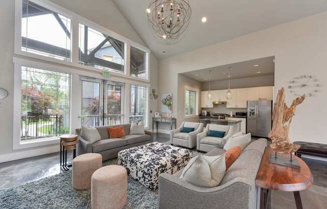 Clubhouse Room with Gray Sofa and Chairs, Full View Glass Doors, View of Kitchen Interior, Carpet and Wood Inspired floor