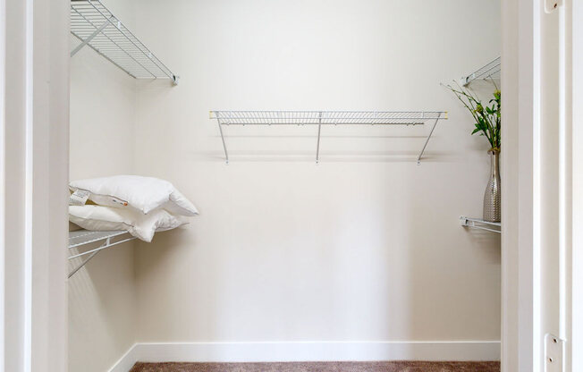a walk in closet in a bedroom with white walls