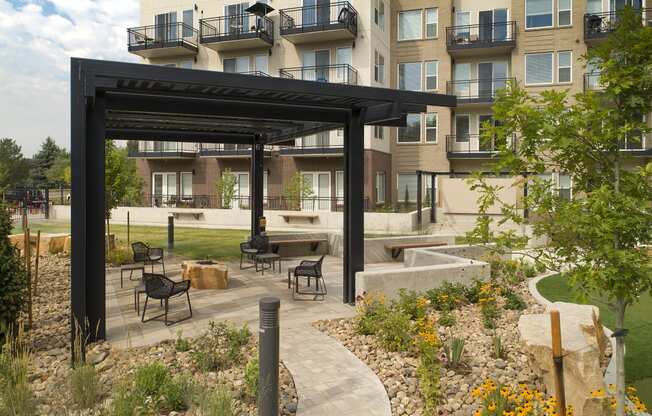 an outdoor patio with a fire pit and a building in the background