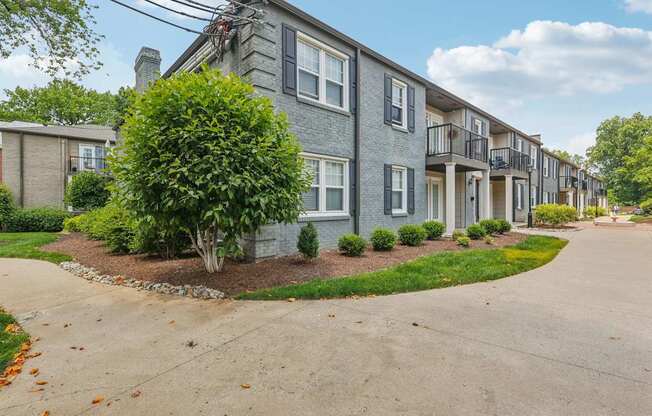 A grey building with a tree in front of it.