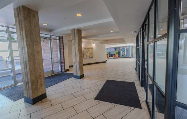 the lobby of a building with windows and rugs