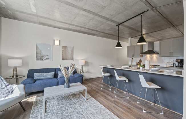 a living area with a sofa coffee table and a kitchen with a breakfast bar  at The Icon, Richmond