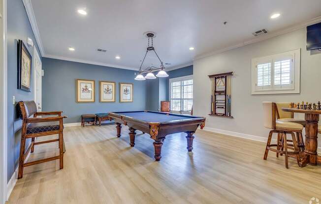 A room with a pool table and a chair.