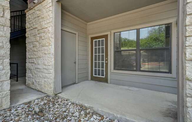 A house entrance with a brown door and a window.