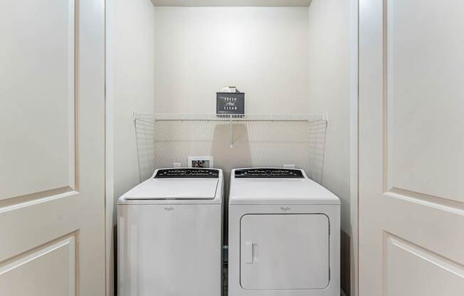 Two white front loading washing machines in a laundry room.