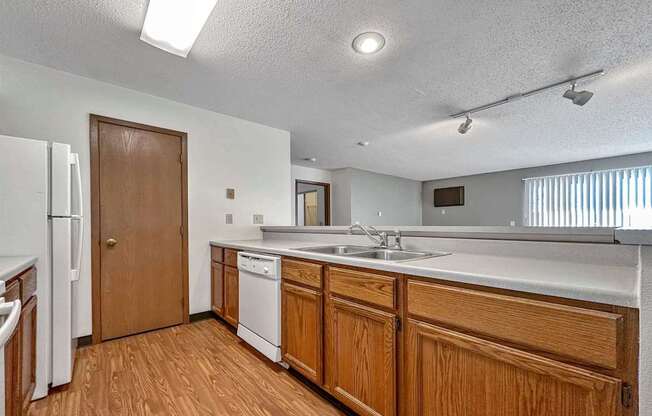 a kitchen with wooden cabinets and a sink and a refrigerator