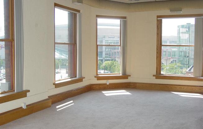 an empty room with three windows and a carpeted floor