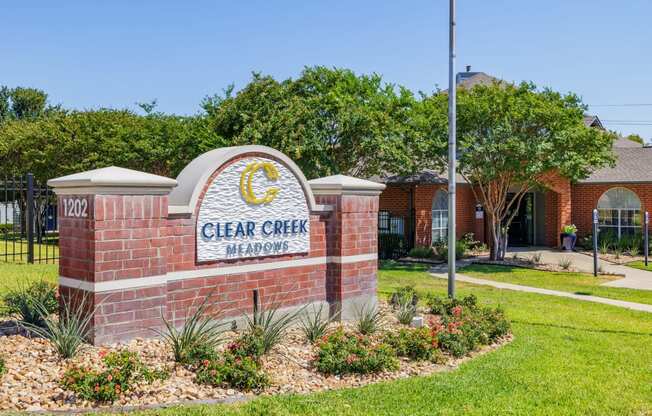 a brick sign with the words clear creek memories in front of a brick building