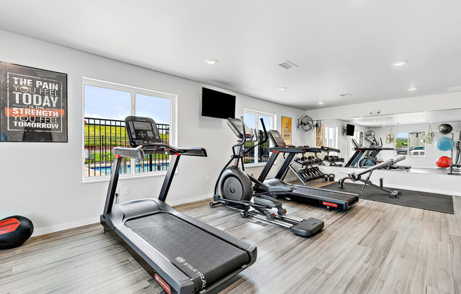 a workout room with treadmills and other exercise equipment