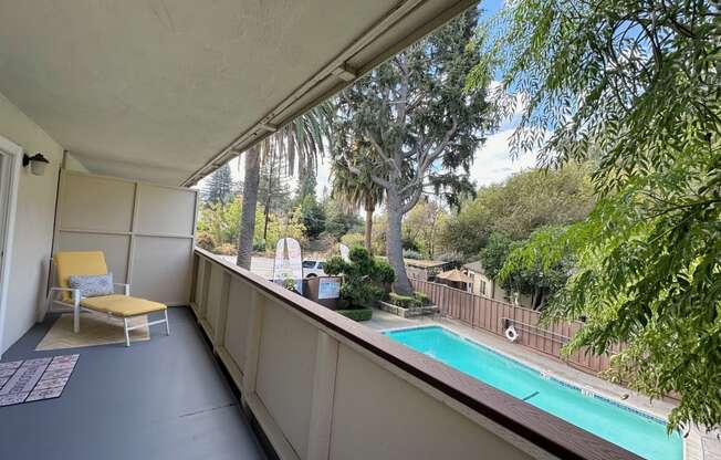 a balcony with a pool and a chair on it