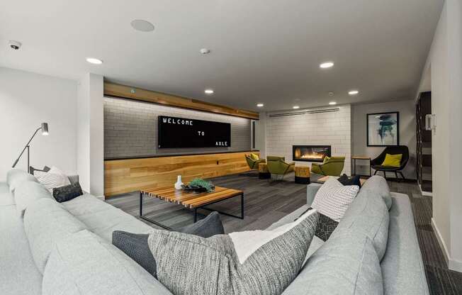 A modern living room with a grey sofa and a wooden bench.