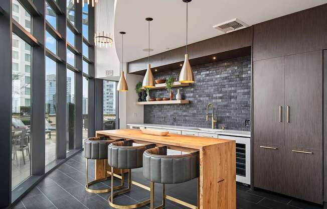 A modern kitchen with a wooden island and grey bar stools.
